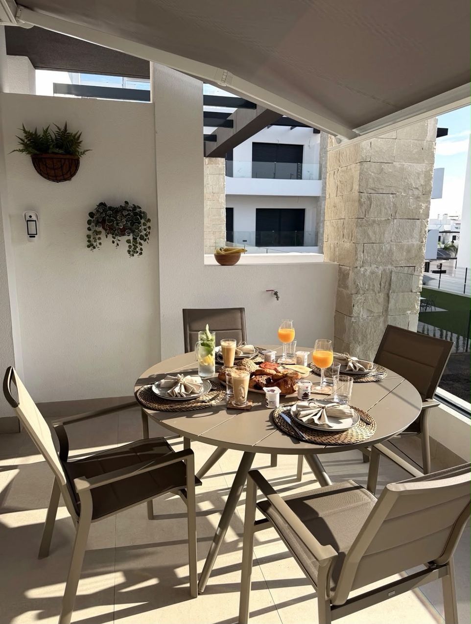 Gedekte ontbijttafel met vier stoelen op het overdekte balkon