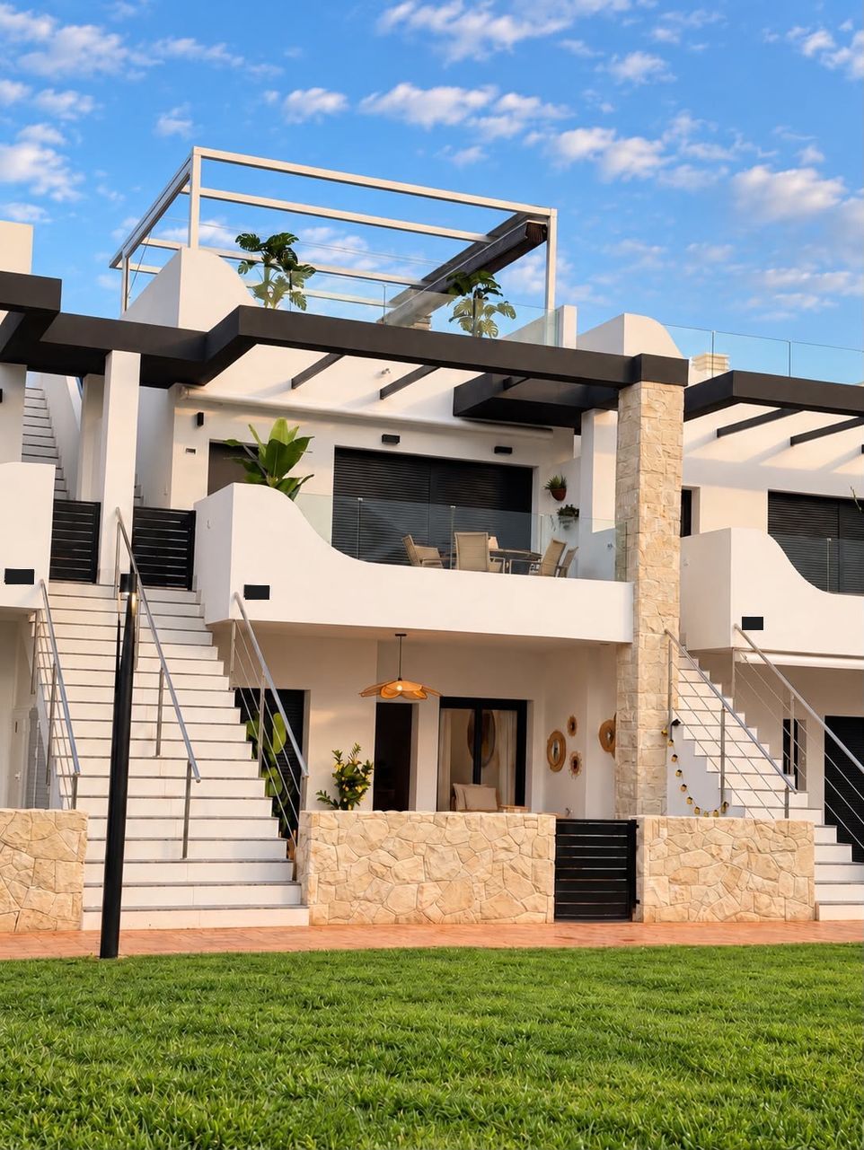 Witte gevel van het appartementencomplex met trappen, balkons en dakterras